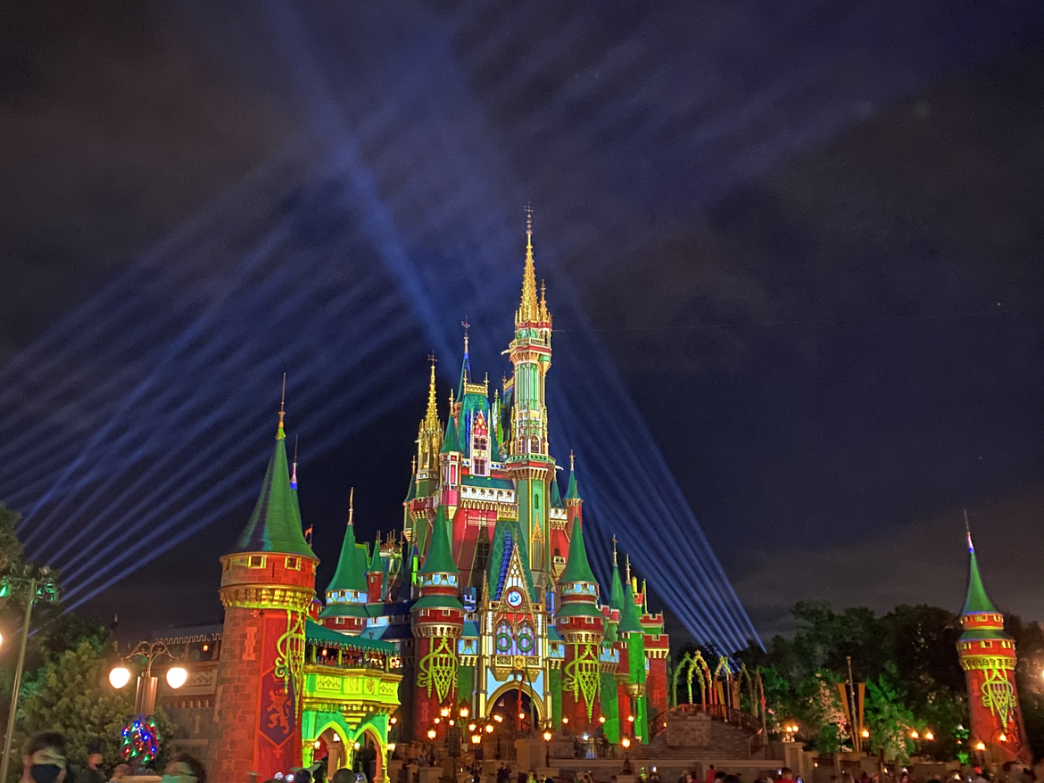 Cinderella's Castle at Magic Kingdom Park at Walt Disney World® Resort is illuminated with holiday projections at night.