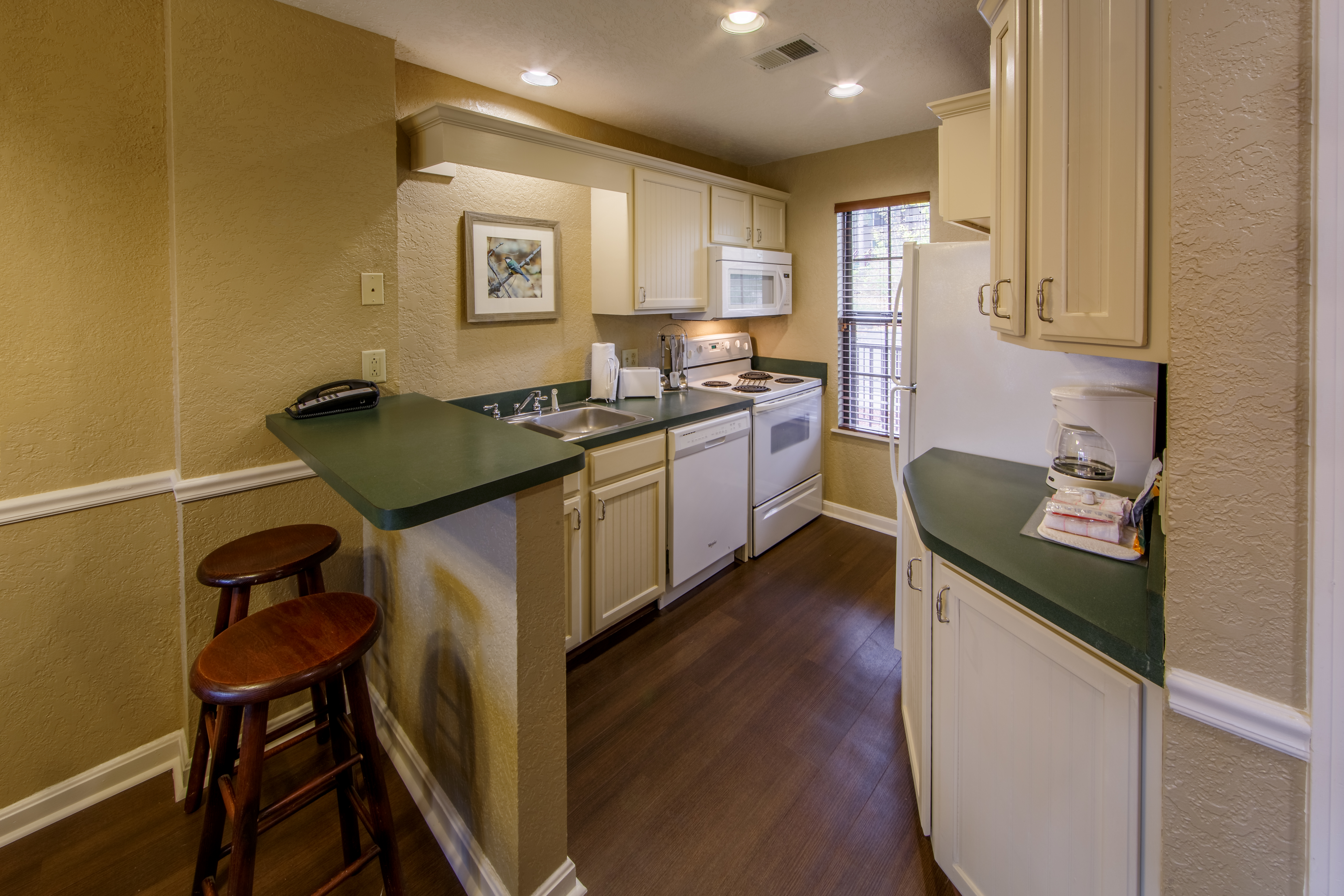 Full kitchen with bart-top and stools in a two bedroom villa at Oak n' Spruce Resort in South Lee, Massachusetts