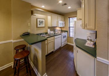 Full kitchen with bart-top and stools in a two bedroom villa at Oak n' Spruce Resort in South Lee, Massachusetts