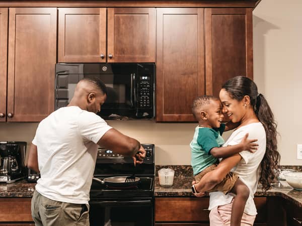 A couple and their child cooking in the a kitchen in a villa at Williamsburg Resort