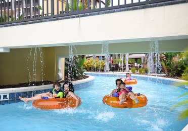 Family floating on inner tubes down lazy river at Orange Lake Resort near Orlando, Florida