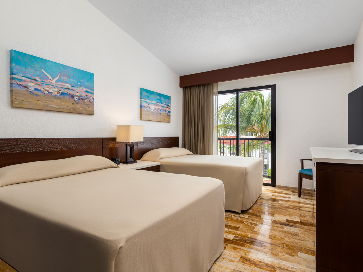Modern bedroom with two twin beds, a window, and coastal artwork.