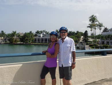 Denise and CJ with their helmets on posing in front of the canal on Marco Island