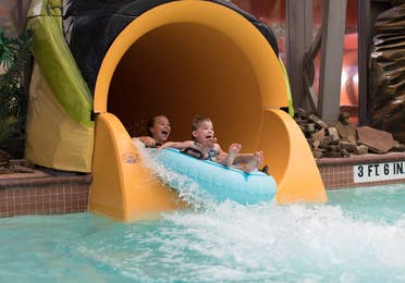 Two children sliding down waterslide at The Waterpark at the Villages at Villages Resort in Flint, Texas.