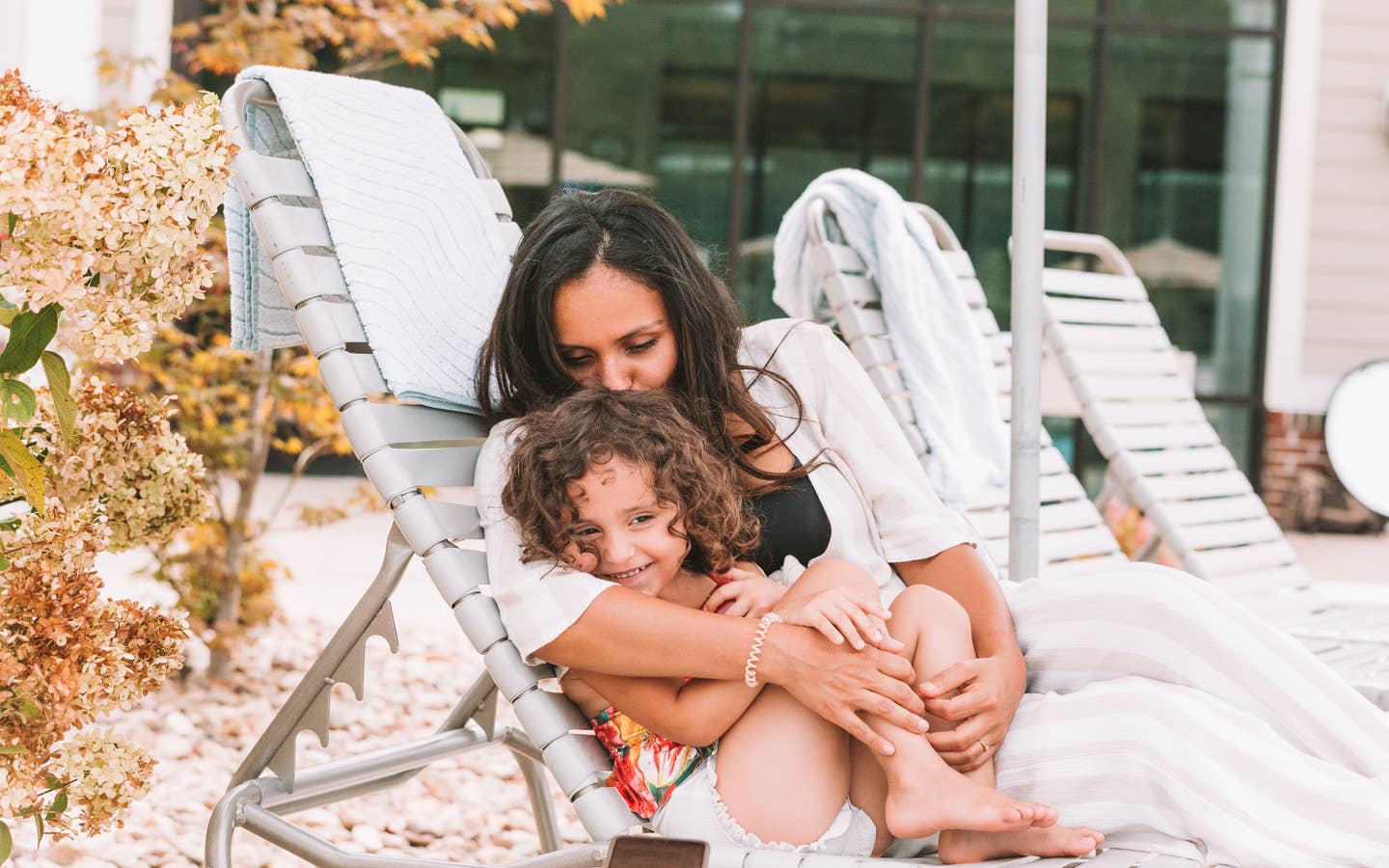 Mother snuggling child outside of pool at Williamsburg Resort.