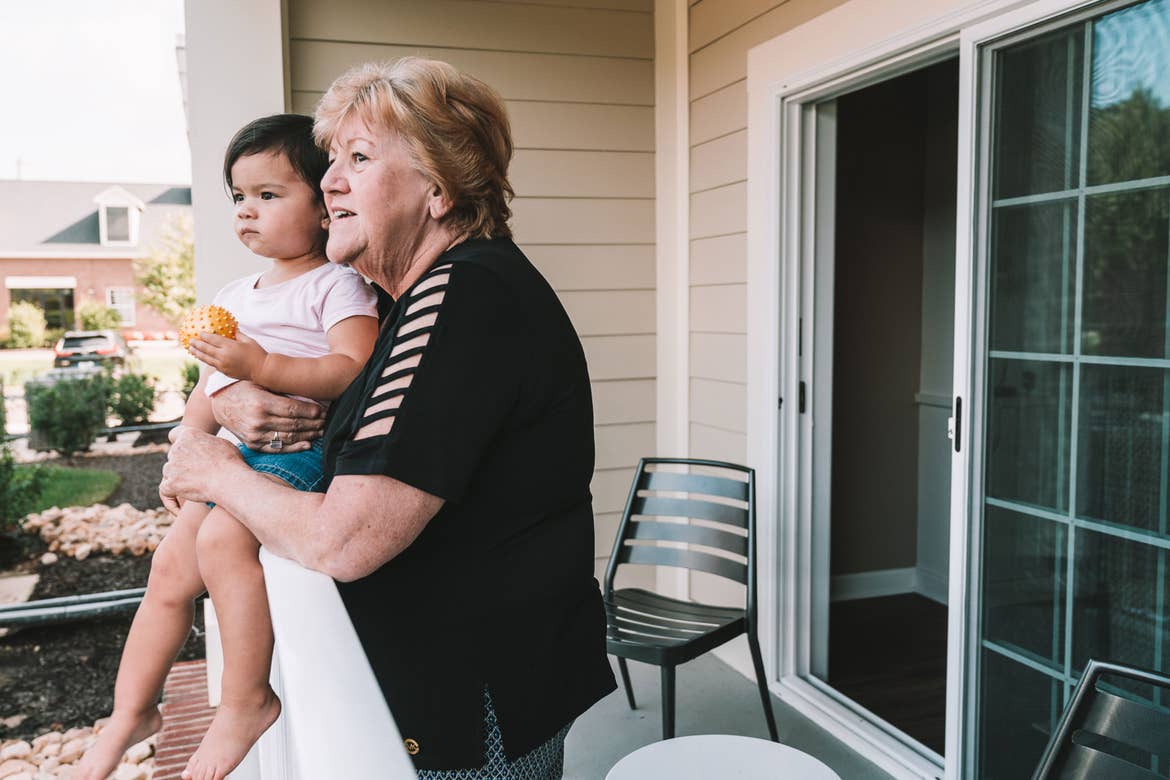 Featured Contributor, Angelica Kajiwara's mother holds Angelica's daughter outside on the patio at our Williamsburg resort in Williamsburg, Virginia.