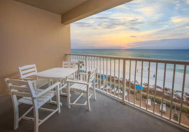 Furnished balcony with table and four chairs and view of ocean in a two-bedroom villa at Panama City Beach Resort