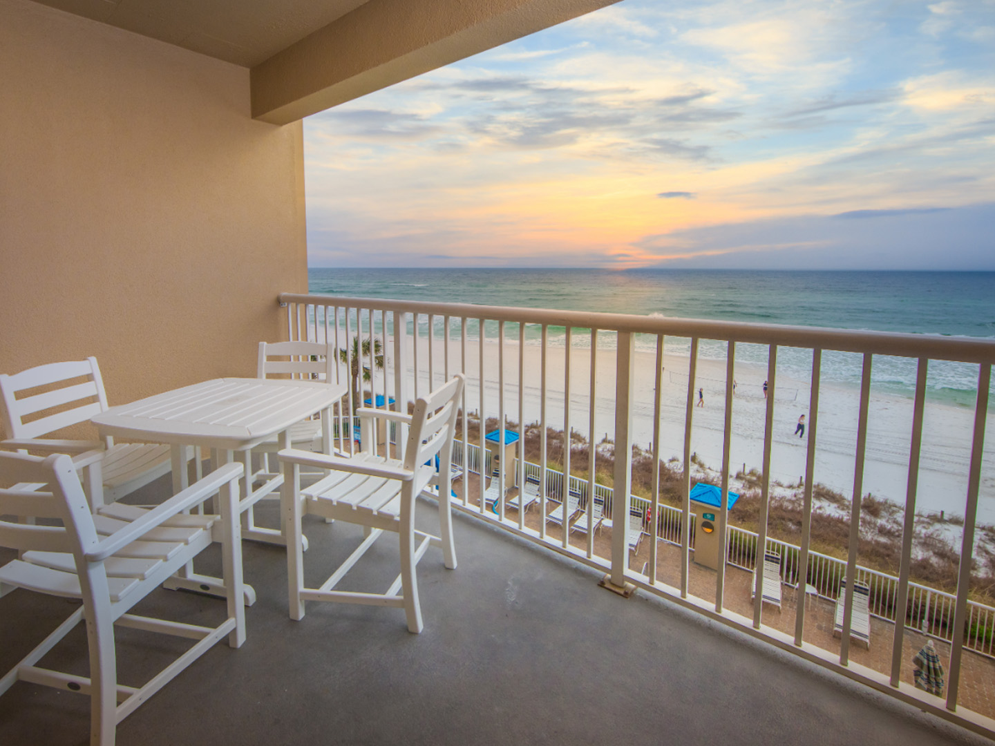 Furnished balcony with table and four chairs and view of ocean in a two-bedroom villa at Panama City Beach Resort