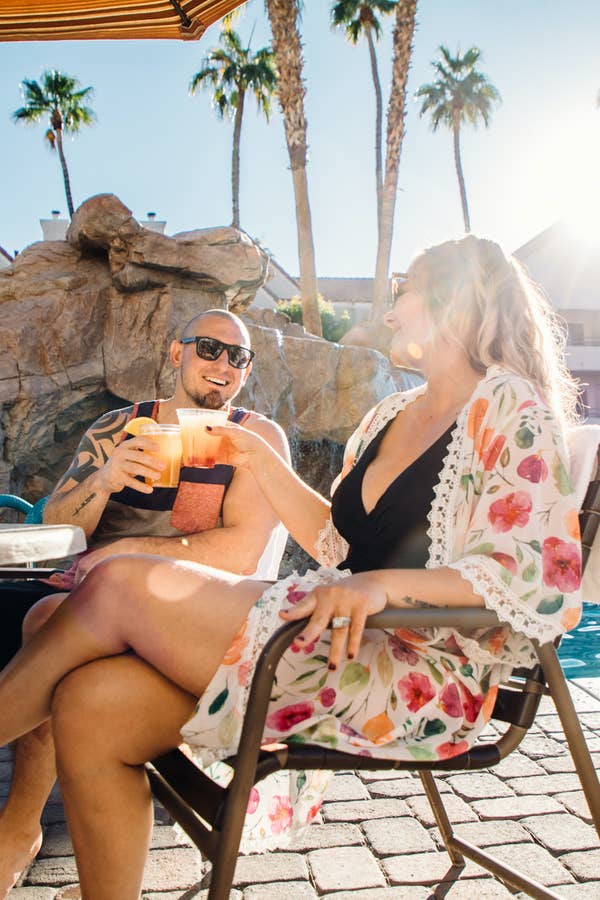 Two guests enjoying drinks by outdoor pool at Desert Club Resort in Las Vegas, Nevada.