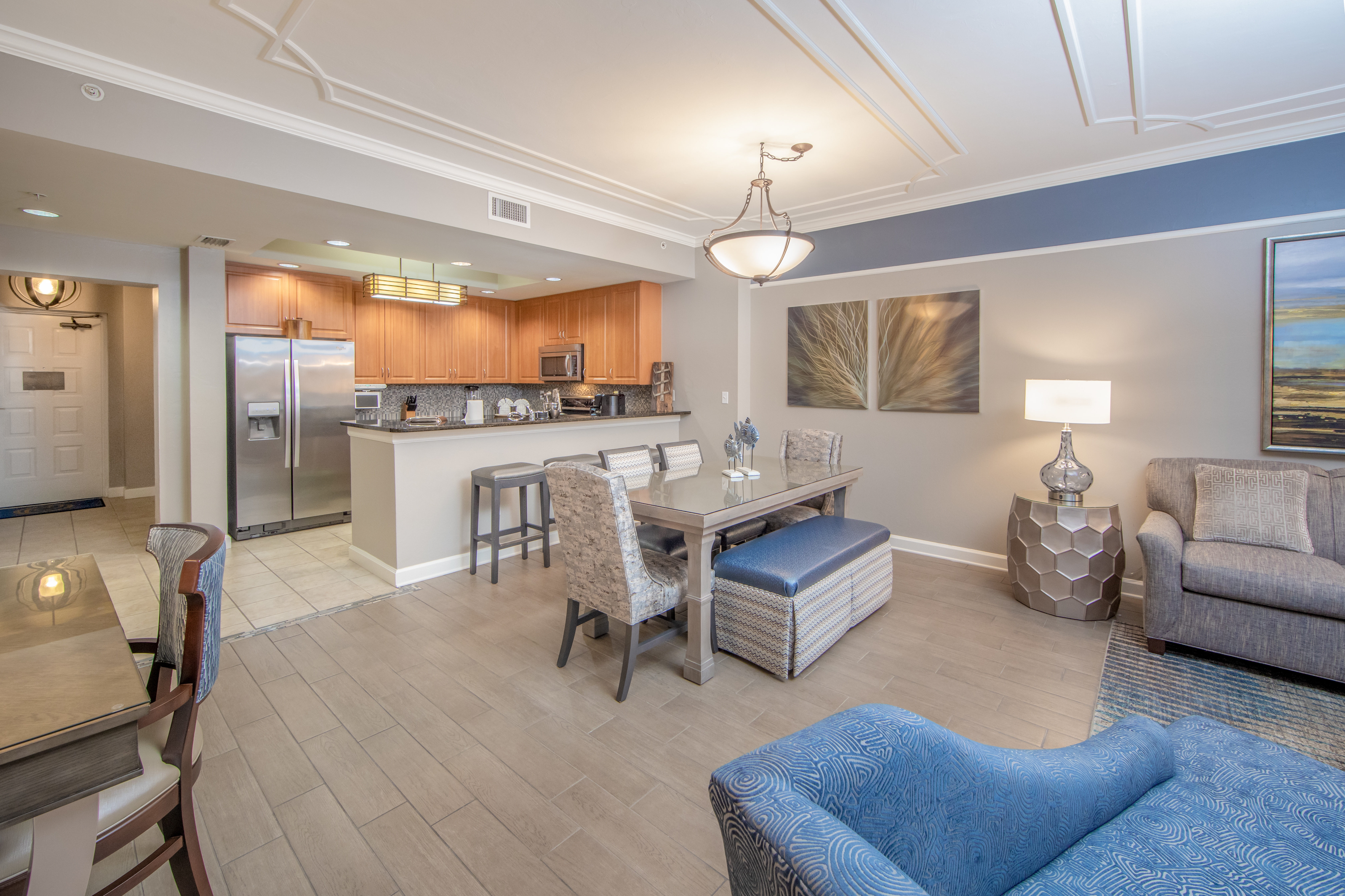 Entire room view with living room, dining table, and kitchen in a three-bedroom villa at Sunset Cove Resort in Marco Island, Florida