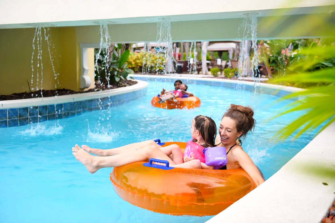 Mom and child floating down lazy river on innertube at Orange Lake Resort near Orlando, Florida