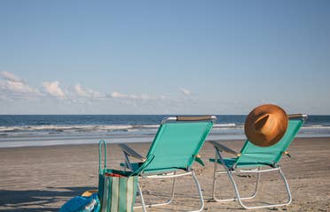 Two beach chairs sitting on beach near Cape Canaveral Beach Resort in Florida.