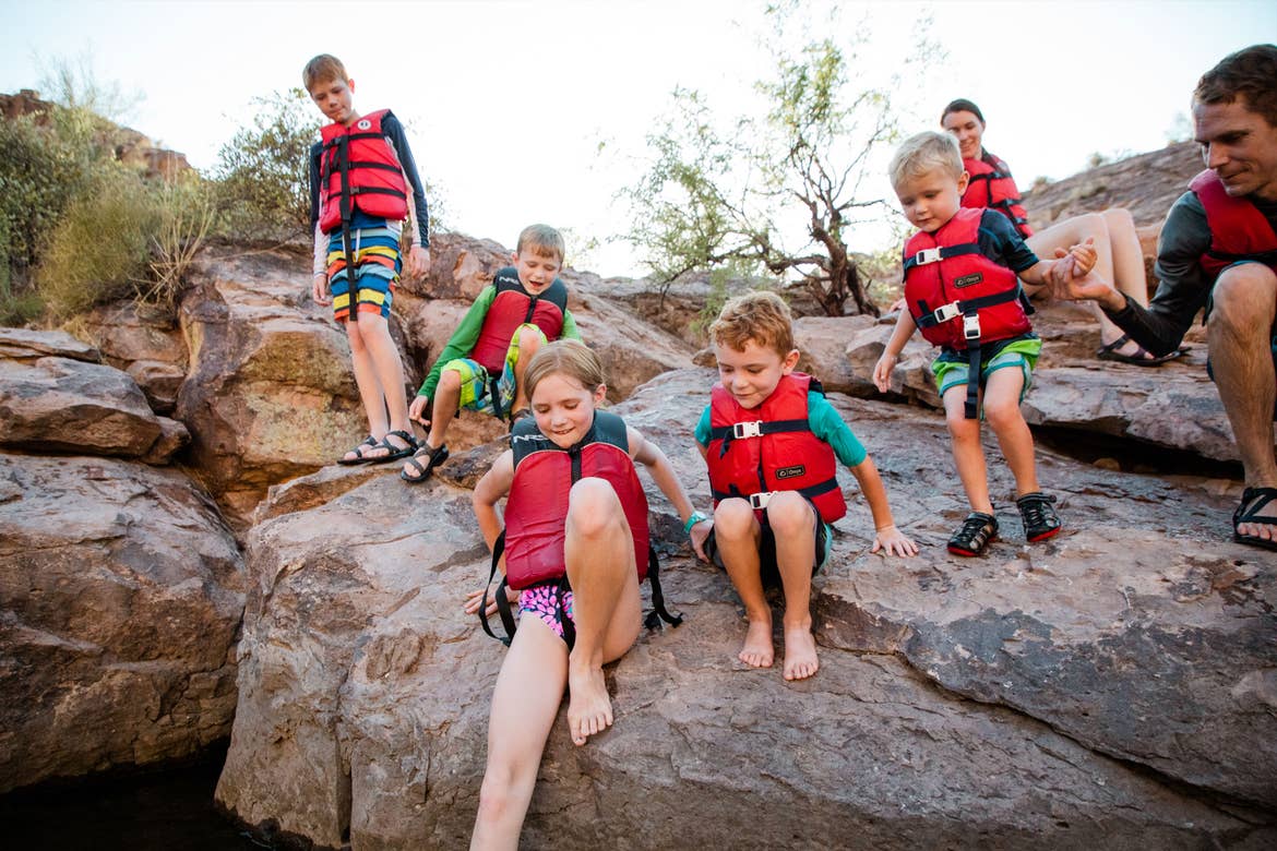 The Averett family wearing their life jackets on a cliff near the edge of the lake.