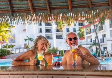 Couple sitting at poolside bar.
