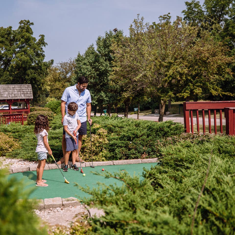 Family playing mini golf at Fox River Resort in Sheridan, Illinois.