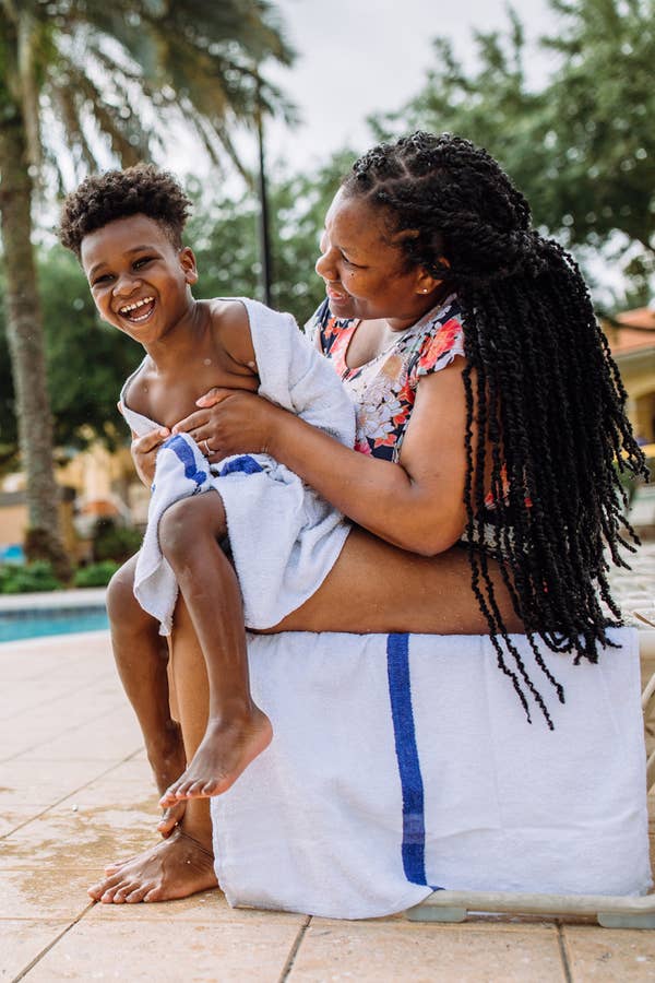 Mother holding child wrapped in towel outside of pool at Orange Lake Resort near Orlando, Florida.