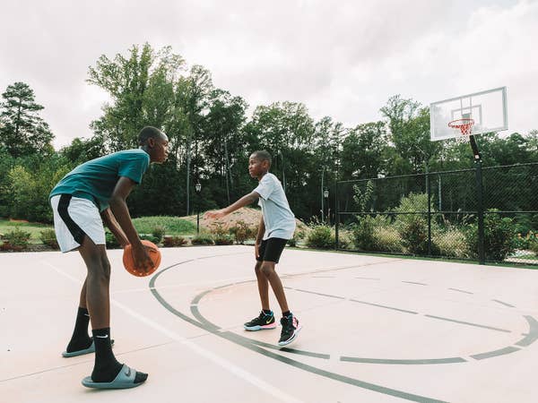 Two teens playing basketball on an outdoor court
