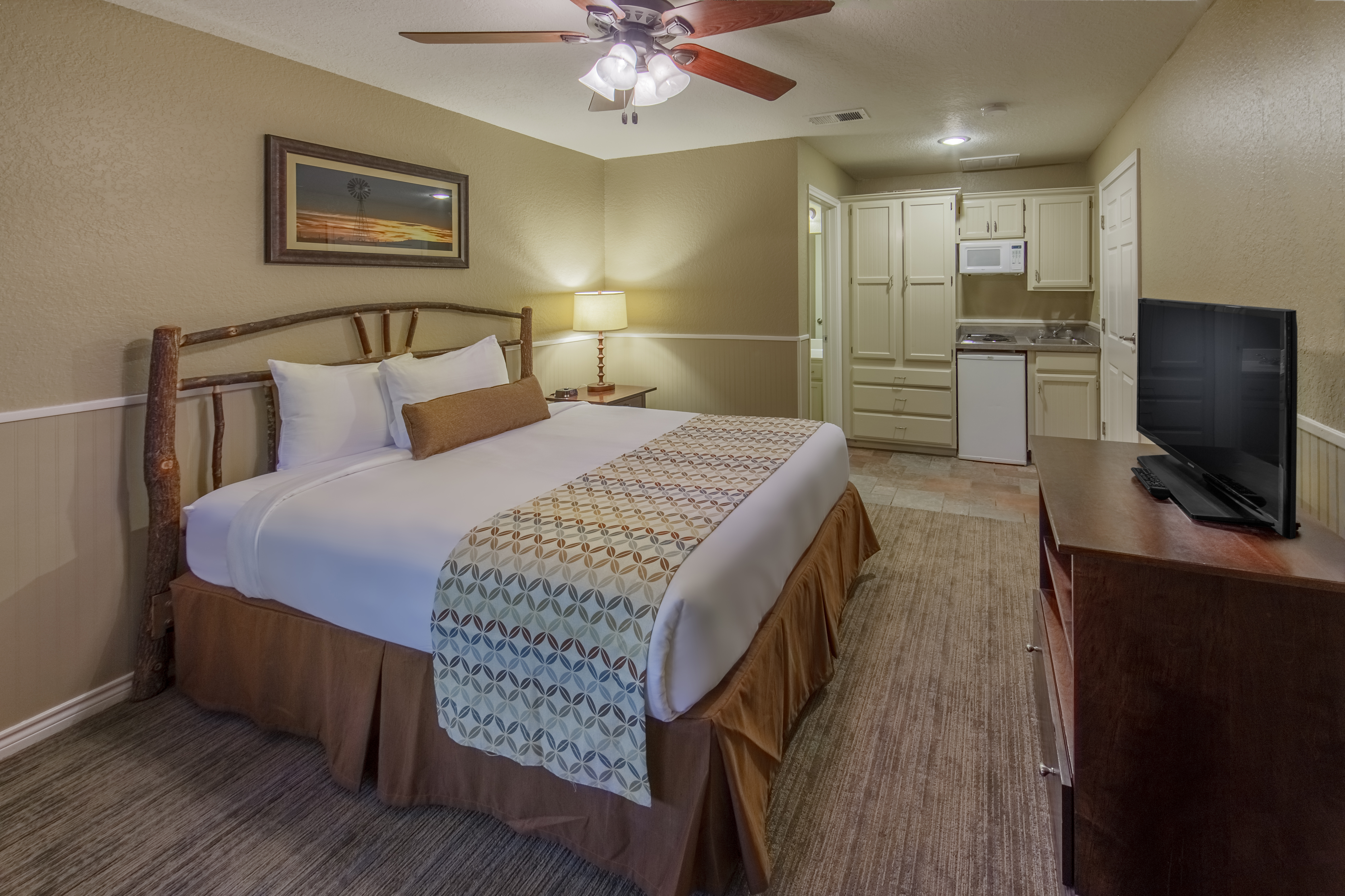 Bed in a  two-bedroom lock-off with a view of the kitchenette at Villages Resort