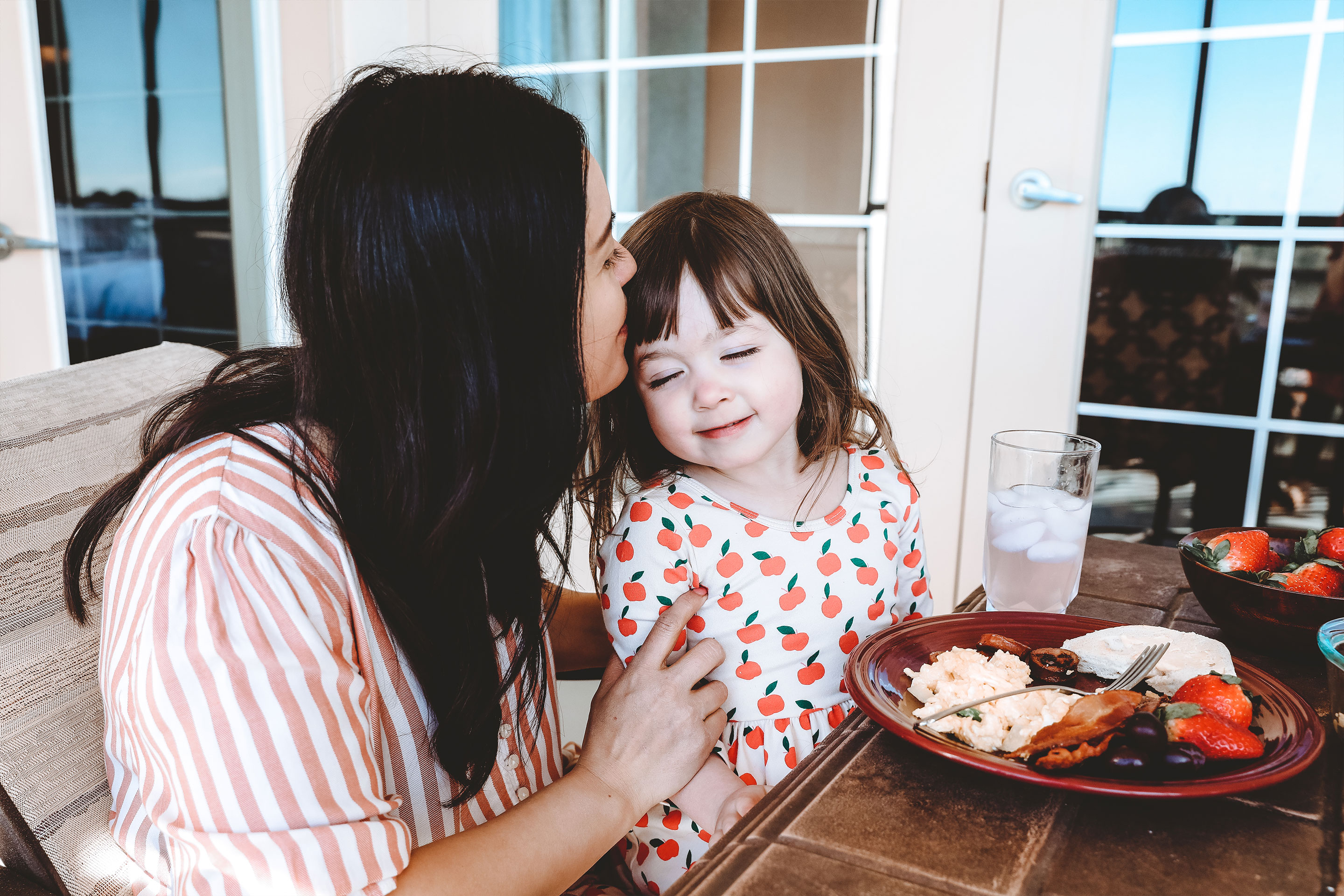 Featured contributor, Mia St. Clair (left), and daughter, Roux (right), enjoy breakfast together on the patio at Orange Lake Resort in Orlando, FL.