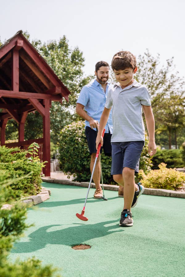 Father and child playing mini golf at Fox River Resort in Sheridan, Illinois.