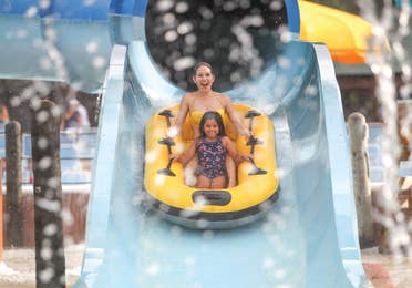 Family tubing down a water slide near Hill Country Resort in Canyon Lake, Texas
