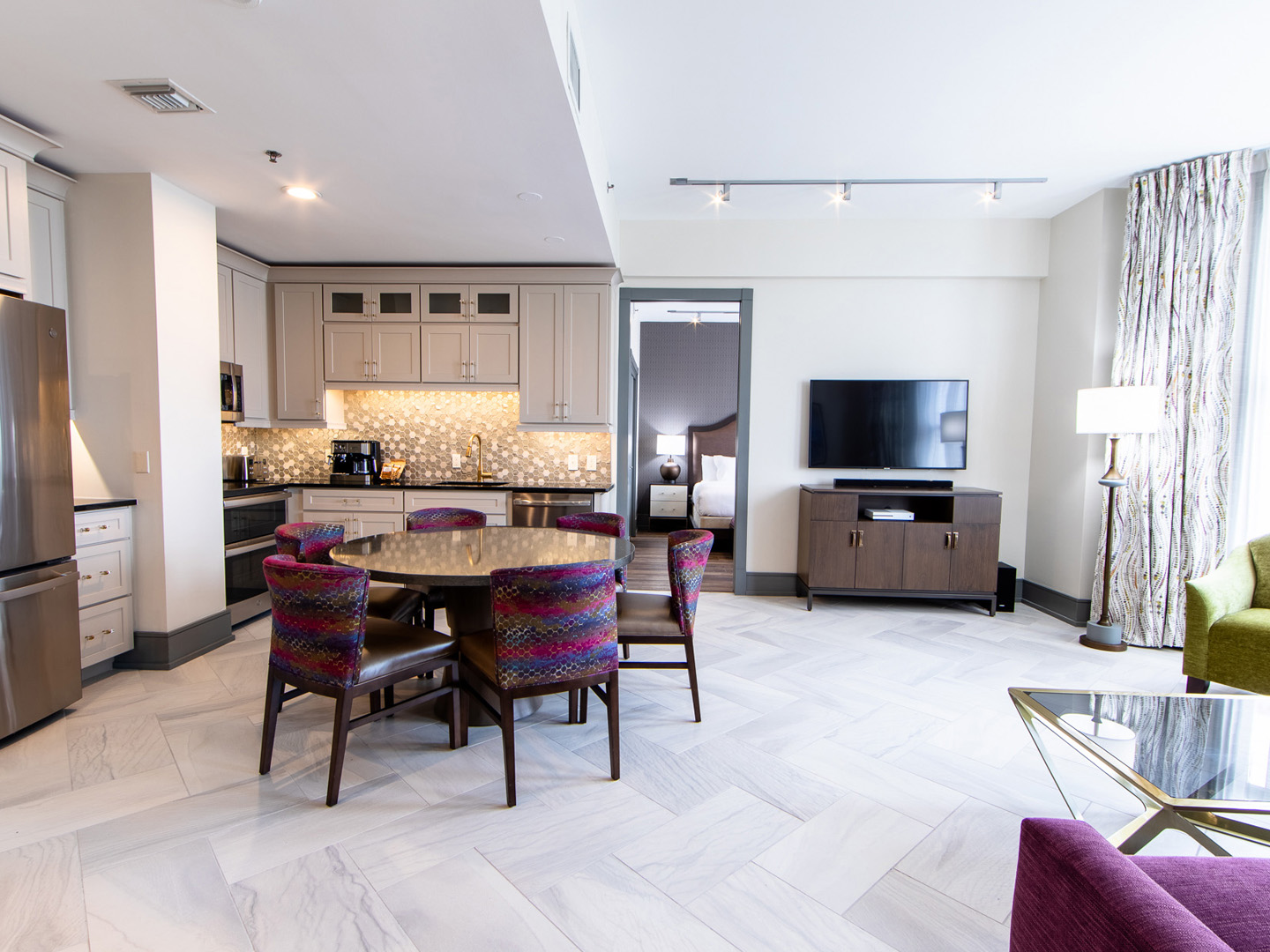 Signature Collection two bedroom villa living area with TV, dining area and full kitchen at New Orleans Resort in Louisiana.