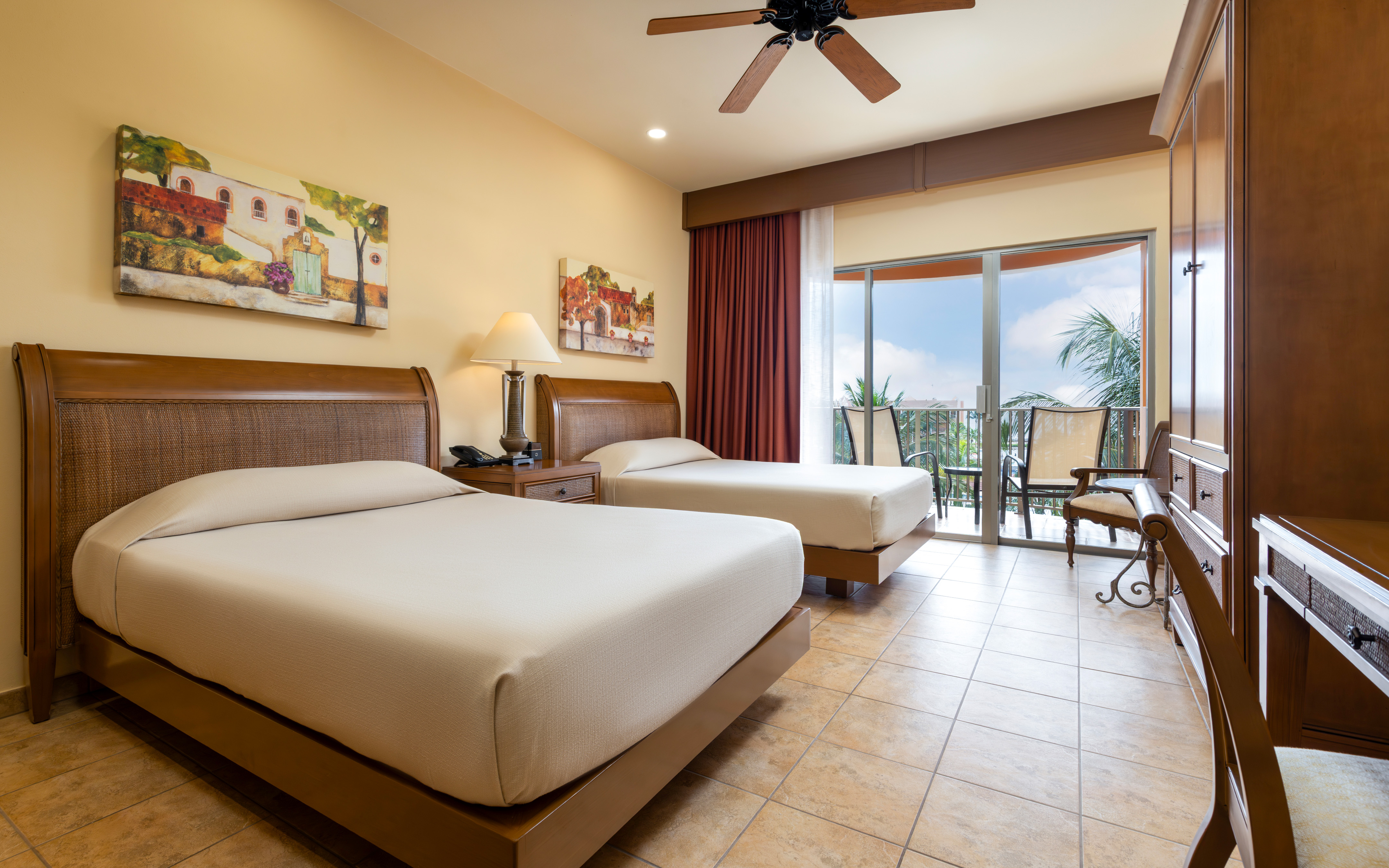 Oceanview bedroom with balcony and two comfortable beds.