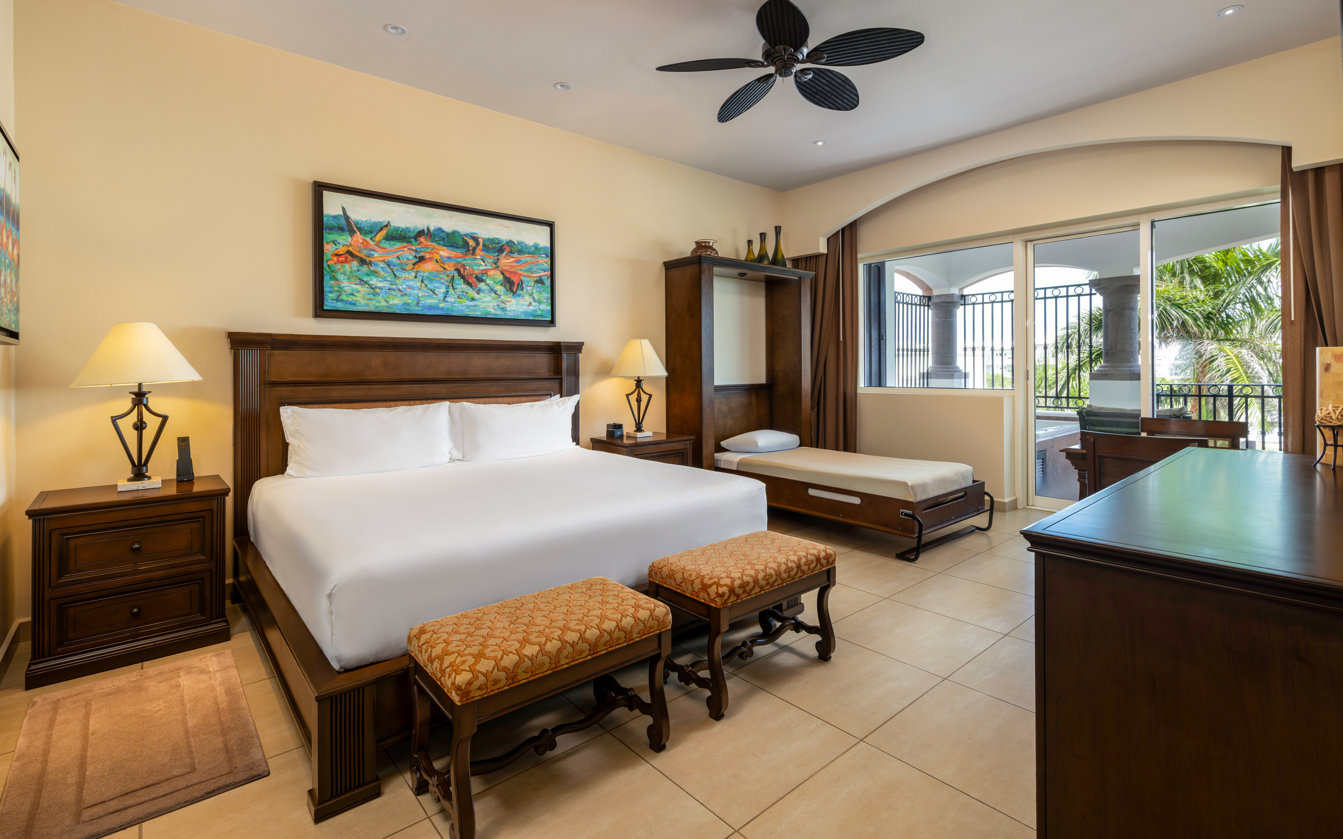 Spacious master bedroom with king bed, daybed, and balcony.