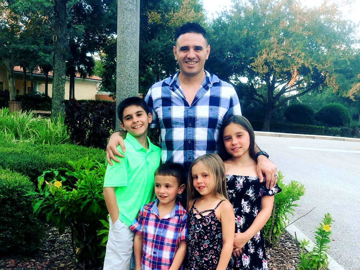 Featured Member, Sara Perezes husband poses with their four children outdoors.