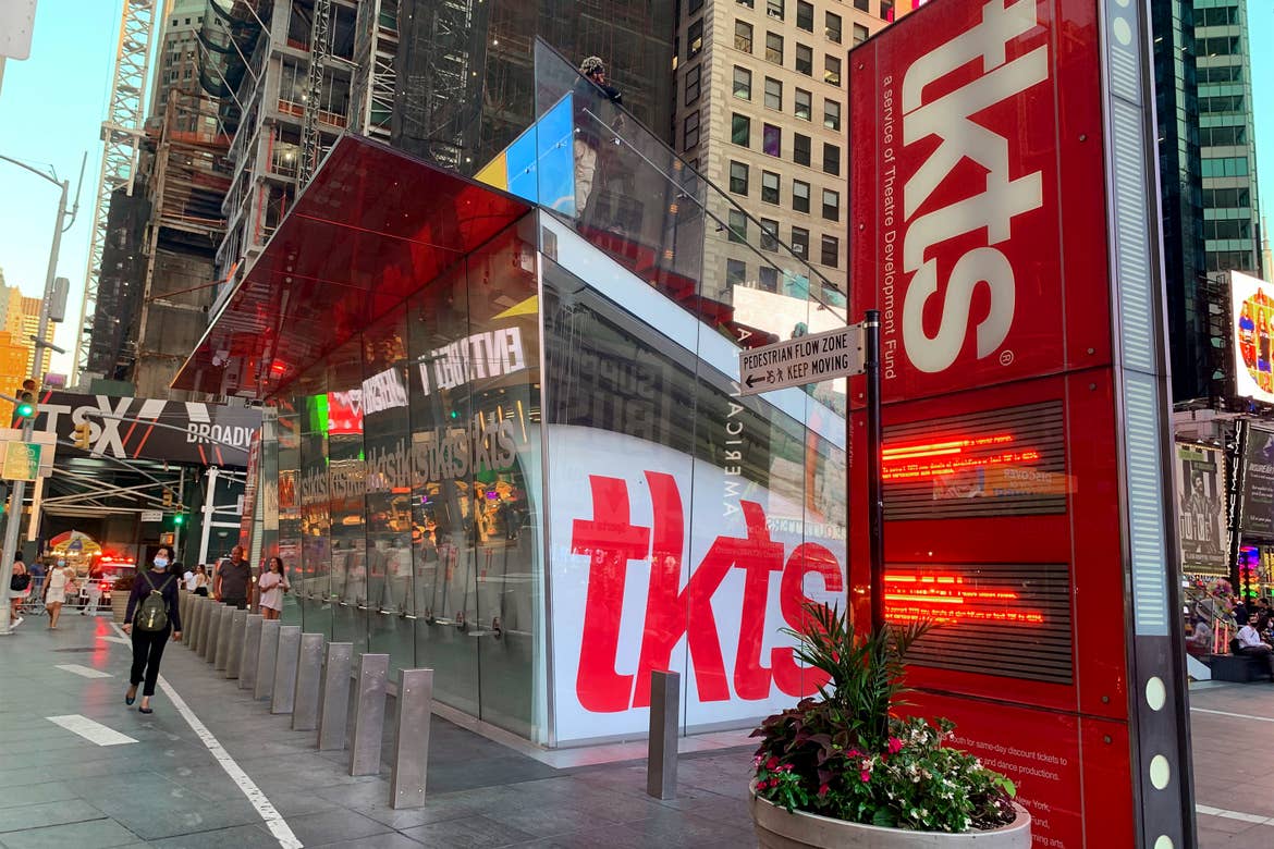 A glass-paneled building with red and white signage that reads 'tkts' in New York City.
