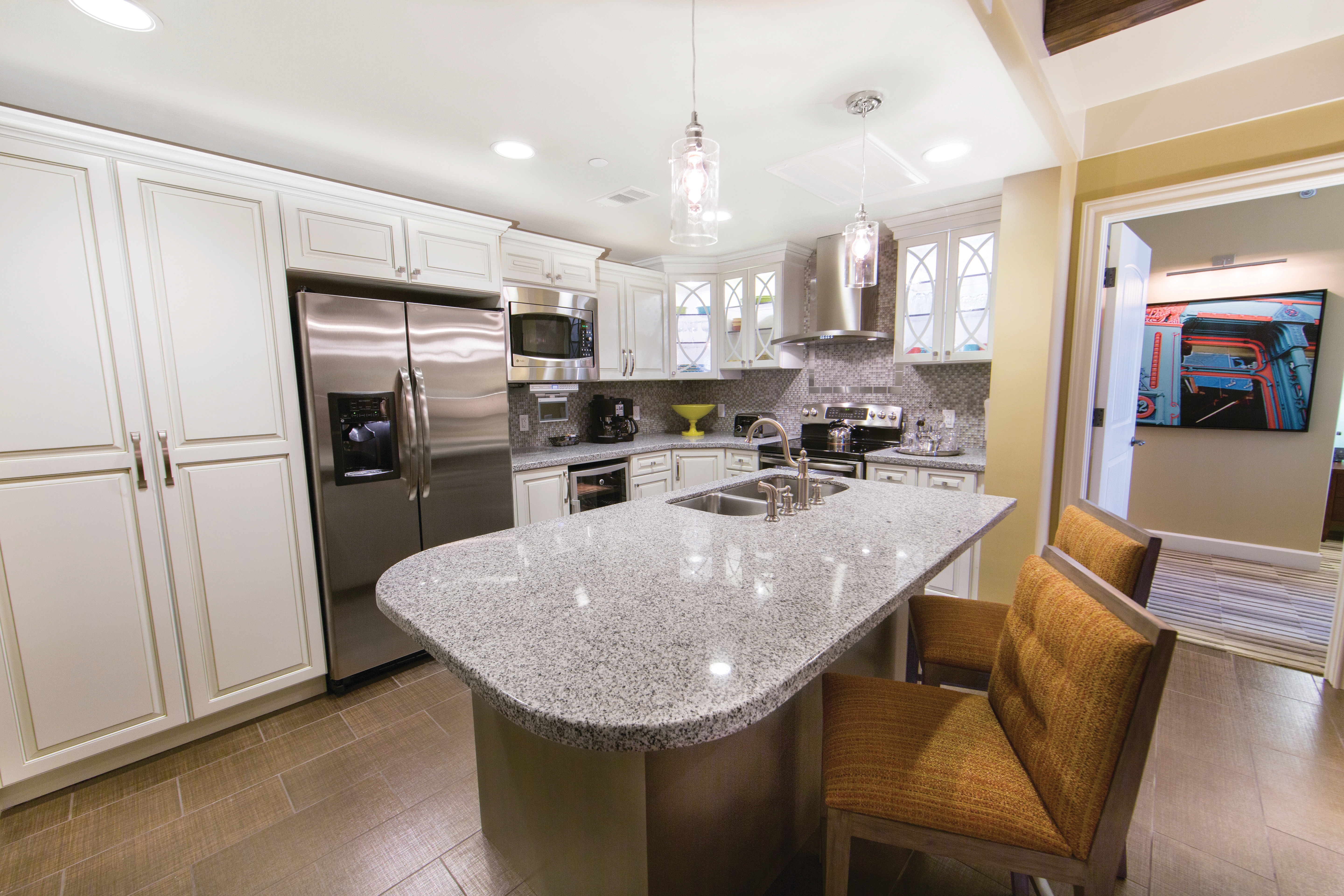 Full kitchen with large island and stainless steel fridge, oven, microwave, sink, and large pantry in a Signature two-bedroom villa at Galveston Beach Resort