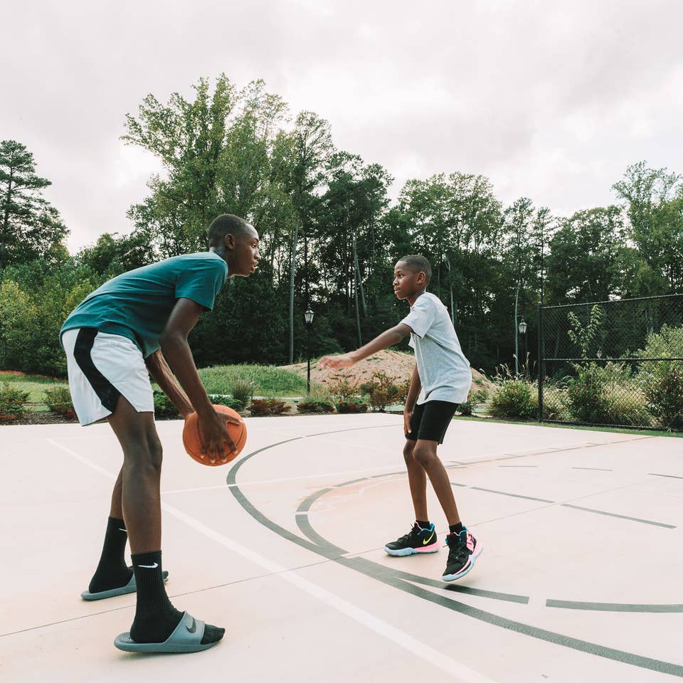 Adult and child playing basketball outdoors at Williamsburg Resort.