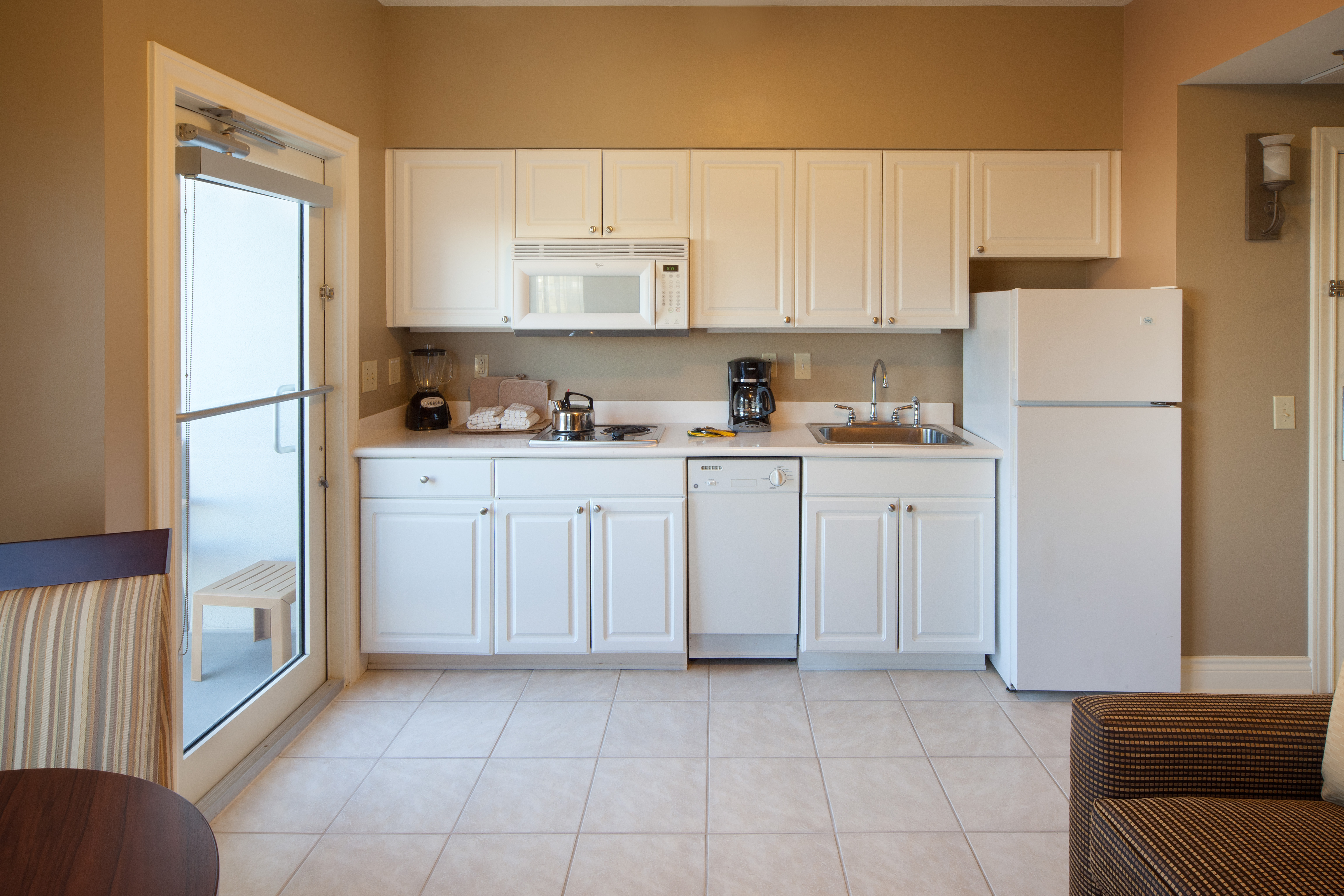 Kitchen with fridge, microwave, dishwasher, and stovetop in a villa at Galveston Beach Resort