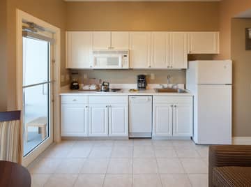 Kitchen with fridge, microwave, dishwasher, and stovetop in a villa at Galveston Beach Resort
