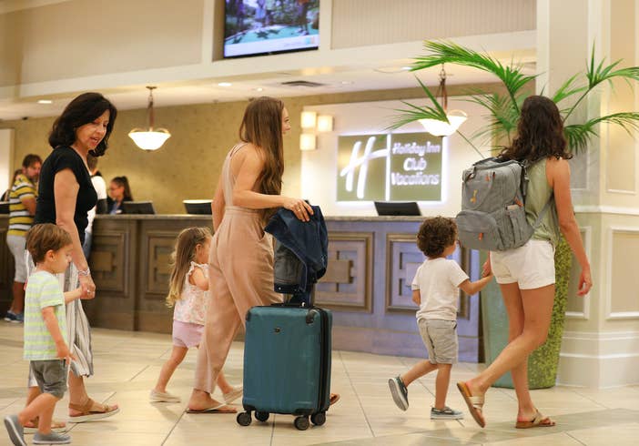 Family of six pulling luggage through lobby of Orange Lake Resort near Orlando, Florida.