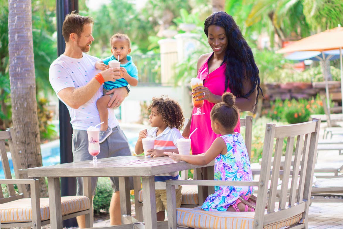 Featured Contributor, Sally Butan (back-right) and her family of five enjoy some beverages at a table near the lazy river at our Orange Lake resort located near Orlando, FL.