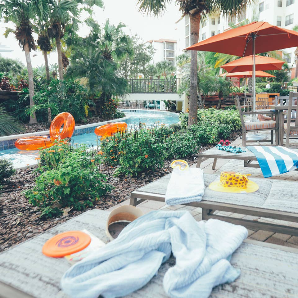 Beach chairs with swimming toys and towels placed next to our lazy river at Orange Lake Resort in Florida.