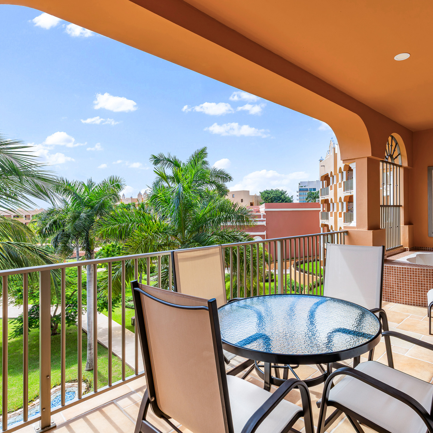 Garden-view balcony with dining set and soaking tub.