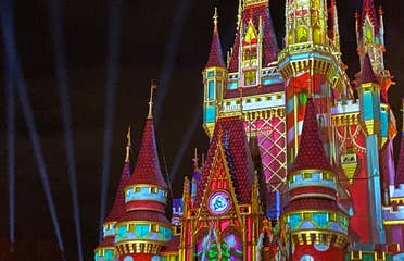 Cinderella's Castle at Magic Kingdom Park at Walt Disney World® Resort is illuminated with holiday projections at night.