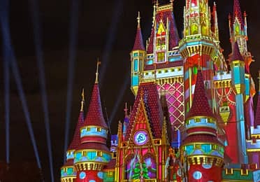 Cinderella's Castle at Magic Kingdom Park at Walt Disney World® Resort is illuminated with holiday projections at night.