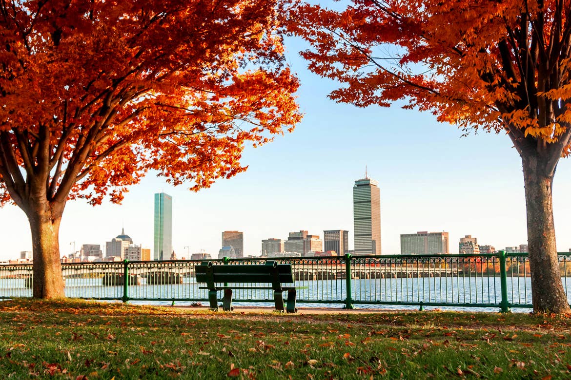 The Charles River Esplanade overlooks the Boston skyline surrounded by fall foliage.