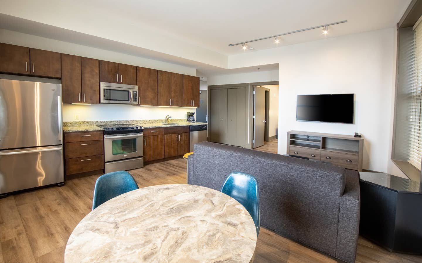 One bedroom villa living room with full kitchen, dining area, couch and TV at New Orleans Resort in Louisiana.