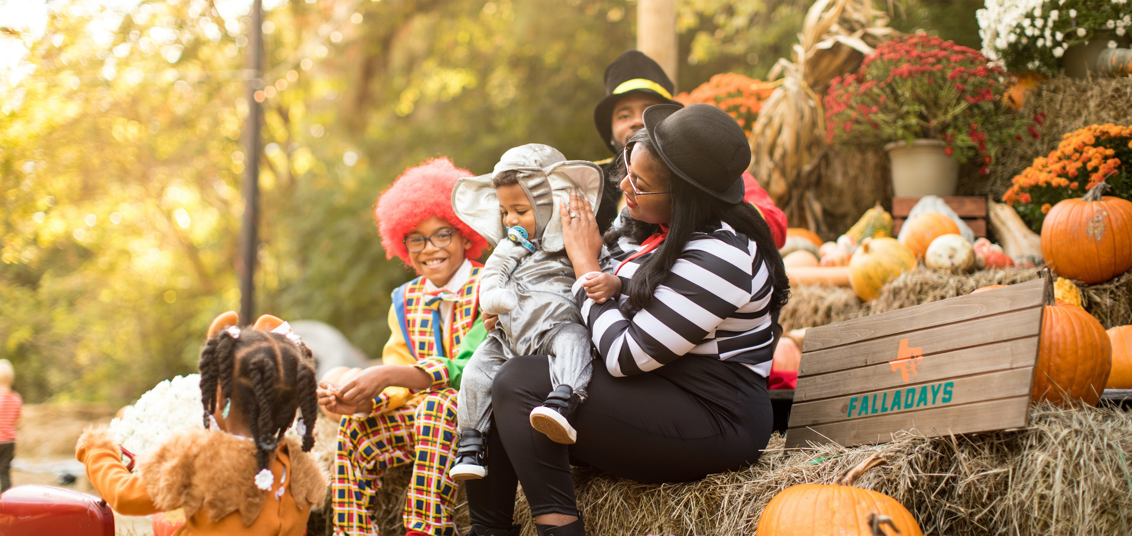 Family in costumes sitting on a pumpkin patch at the Villages Resort in Flint, TX.