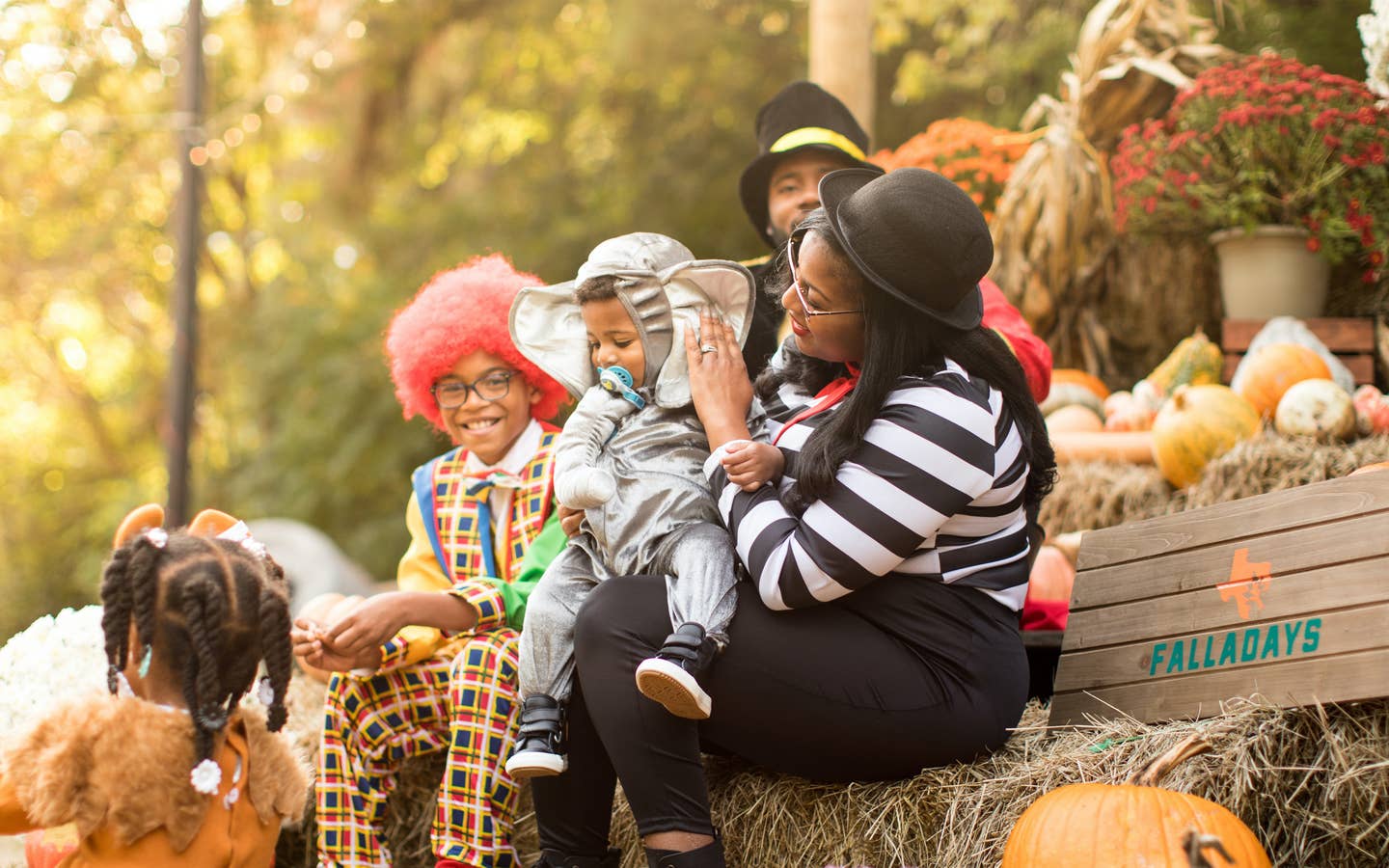 Family in costumes sitting on a pumpkin patch at the Villages Resort in Flint, TX.