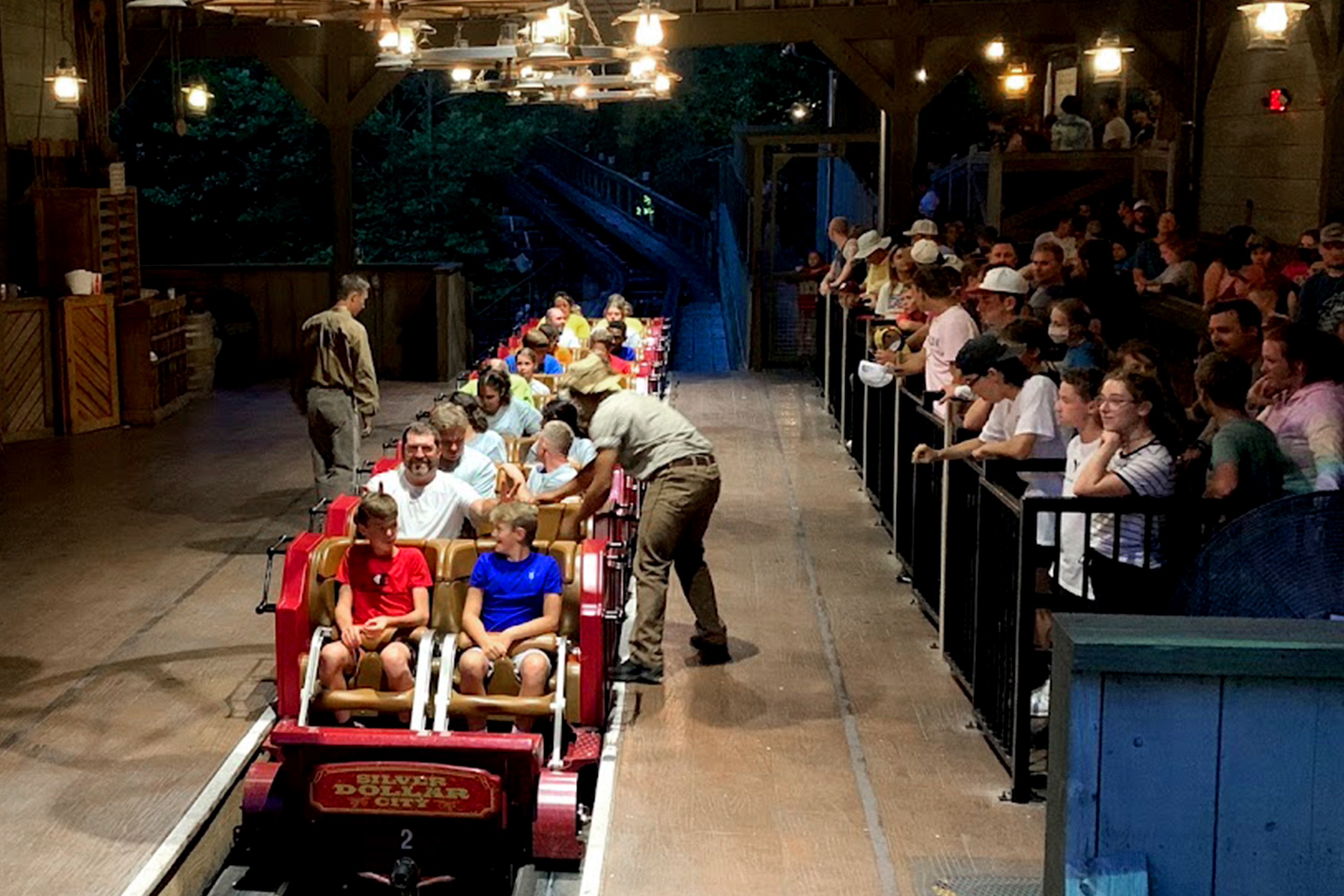 Multiple riders load onto a roller coaster vehicle at Silver Dollar City.