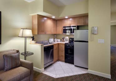 Kitchenette with stainless steel fridge, microwave, dishwasher, sink, and small oven in a villa at Lake Geneva Resort