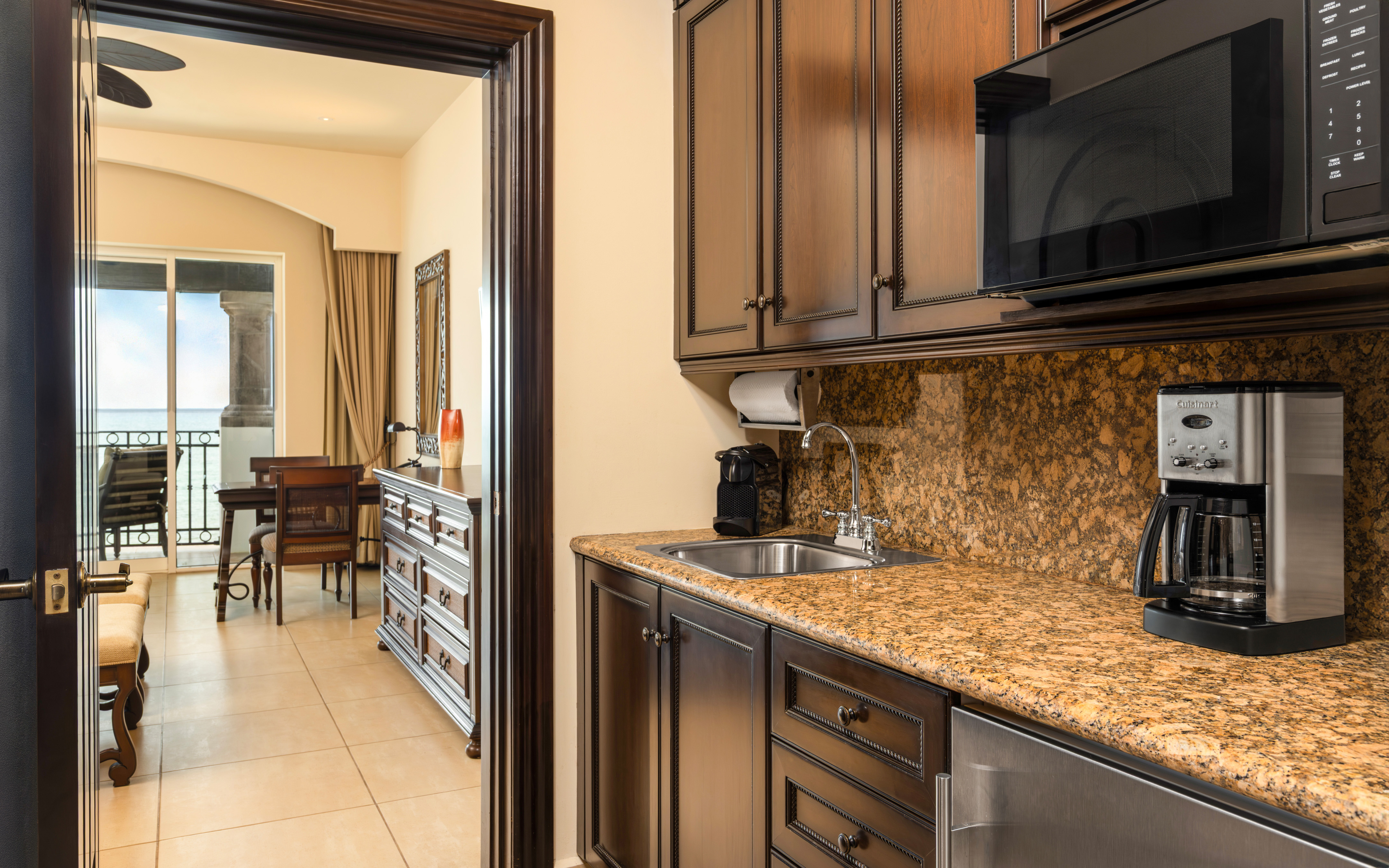 Kitchenette with dark wood cabinets and granite countertop.