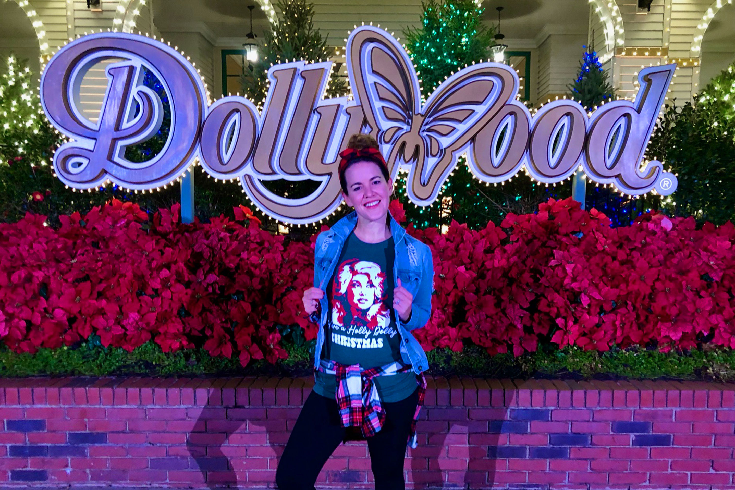 Featured Contributor, Jennifer C. Harmon, sports a Dolly-inspired shirt in front of the Dollywood marquee at 'Dollywood.'