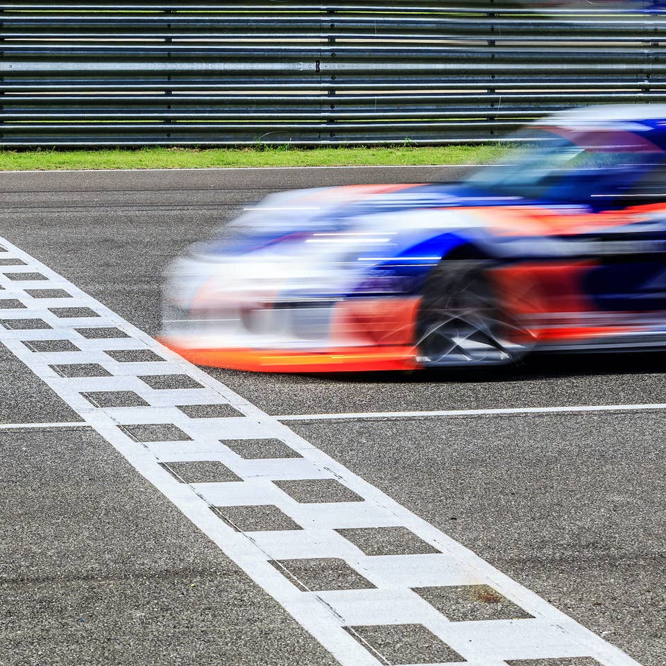 Race car crossing finish line at a race.