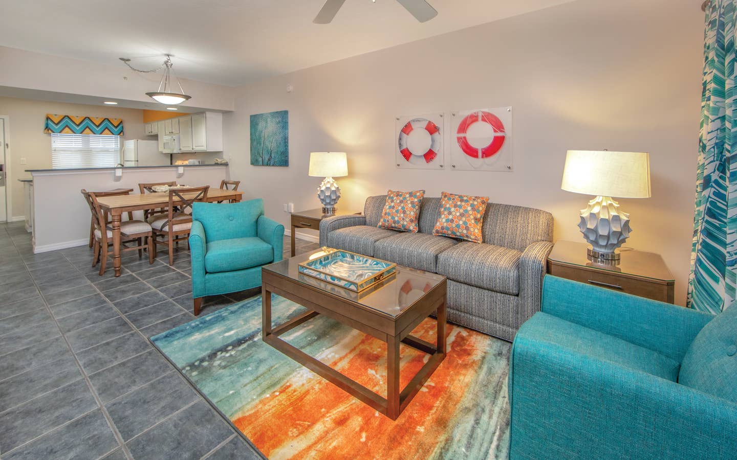 Living room with couch, two accent chairs, and coastal decor in a one-bedroom villa at Panama City Beach Resort